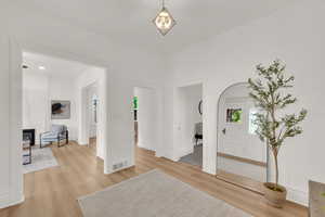 Unfurnished living room featuring light wood finished floors and baseboards