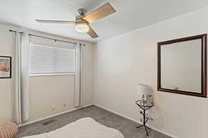 Carpeted bedroom with baseboards and ceiling fan