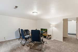 Carpeted dining room featuring baseboards and a textured ceiling