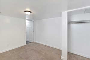 Unfurnished bedroom with carpet flooring, baseboards, and a closet