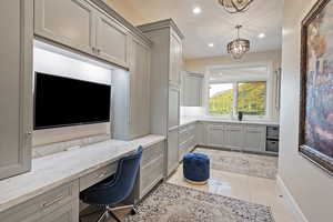 Home office featuring built in study area, light tile patterned floors, recessed lighting, a chandelier, and baseboards
