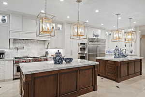 Kitchen with a kitchen island, a chandelier, premium appliances, backsplash, and recessed lighting