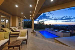 Pool at dusk featuring a patio, an outdoor pool, and an outdoor hangout area