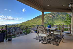 View of patio with a mountain view, a balcony, and outdoor dining space