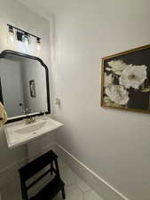 Bathroom with tile patterned floors and baseboards