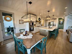 Dining area with a chandelier, light wood-style flooring, stairs, and recessed lighting