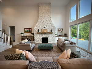 Living area featuring a high ceiling, wood finished floors, plenty of natural light, stairs, and baseboards