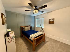 Bedroom featuring carpet, ceiling fan, and a textured ceiling