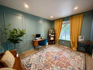 Home office with a decorative wall, wood finished floors, and recessed lighting
