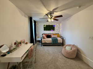 Bedroom featuring carpet, a textured ceiling, and ceiling fan