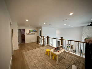 Living area with wood finished floors, recessed lighting, a ceiling fan, an upstairs landing, and baseboards