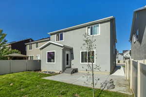 Back of property with stucco siding and a patio
