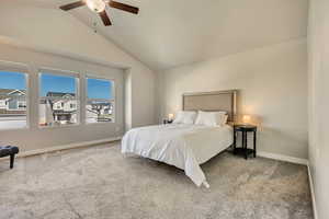 Carpeted bedroom featuring lofted ceiling, baseboards, and ceiling fan