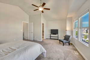 Bedroom with carpet flooring, baseboards, ceiling fan, and high vaulted ceiling