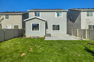 Rear view of house featuring solar panels, stucco siding, and a patio