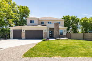 View of front of property featuring stone siding, stucco siding, concrete driveway, and an attached garage