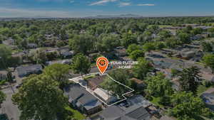 Aerial view of property and surrounding area featuring nearby suburban area and a mountain backdrop