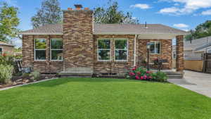 View of front of home featuring a chimney, roof with shingles, and brick siding