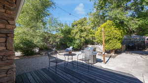 Wooden deck featuring a grill, a fenced backyard, and a patio area
