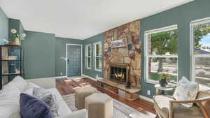 Living area featuring wood finished floors, a fireplace, and baseboards