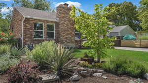 View of side of property with a chimney, brick siding, and a shingled roof