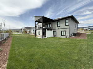 Back of property with a balcony, a patio area, and central air condition unit