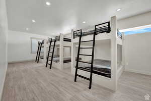 Unfurnished bedroom featuring wood finished floors, baseboards, and recessed lighting