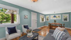 Living room with healthy amount of natural light, a textured ceiling, baseboards, and light wood finished floors