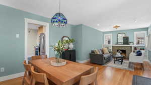 Dining space with baseboards, a textured ceiling, a brick fireplace, light wood-type flooring, and recessed lighting
