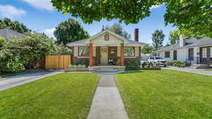 Bungalow-style house featuring brick siding, french doors, and a chimney