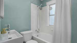 Full bathroom featuring tiled shower / bath, a sink, and toilet