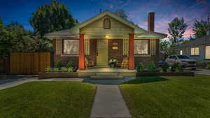 Bungalow-style home featuring brick siding, a porch, and a chimney
