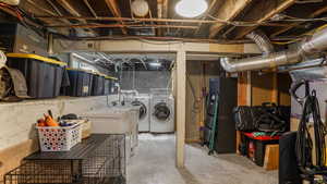 Unfinished below grade area featuring separate washer and dryer