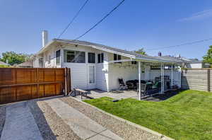 Rear view of property featuring a chimney and a patio area