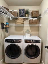 Laundry room with a textured ceiling and washing machine and clothes dryer