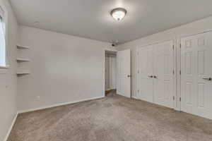 Bedroom  featuring carpet floors, baseboards, and multiple closets