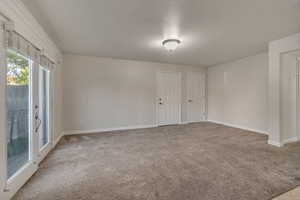 Carpeted Living Room featuring double open french doors with Juliet balcony and large closet by entry door