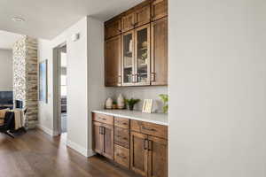 Bar area featuring dark wood-style floors and baseboards