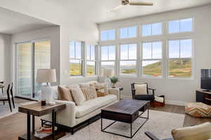 Living room featuring ceiling fan, baseboards, and light wood finished floors