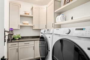 Washroom featuring separate washer and dryer and cabinet space