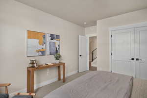 Carpeted bedroom featuring baseboards and a closet