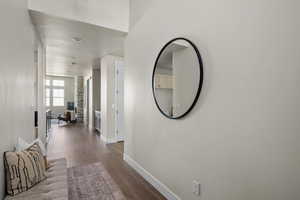 Hall featuring baseboards and dark wood-style floors
