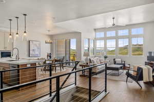 Living room featuring plenty of natural light, wood finished floors, a ceiling fan, and recessed lighting