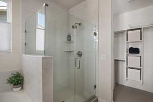 Bathroom with a stall shower, a bath, and a walk in closet