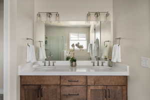 Bathroom featuring double vanity and a stall shower