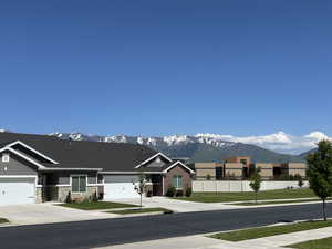 View of asphalt street featuring a mountain view and sidewalks