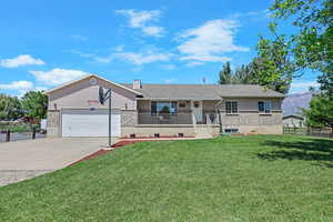 Single story home featuring an attached garage, driveway, covered porch, and a chimney