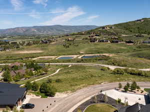 Aerial view of property and surrounding area featuring a water and mountain view