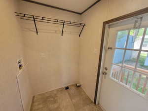 Laundry area featuring plenty of natural light, washer hookup, stone finish flooring, and ornamental molding