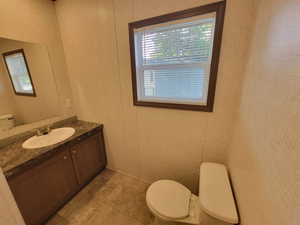 Half bath featuring toilet and vanity